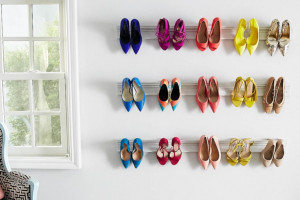 Colourful shoes hanging on a custom wall shoe hanger.